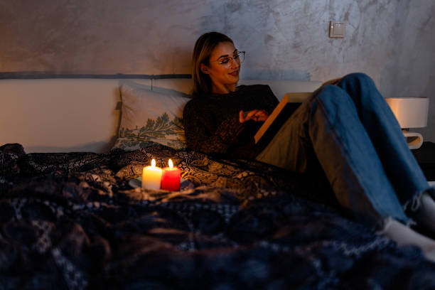 istock A woman is reading a book during blackout time during an energetic crisis. 1454358122