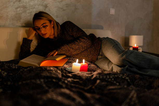 istock A woman is reading a book during blackout time during an energetic crisis. 1454358372
