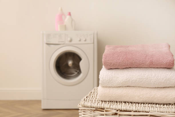 istock Clean folded towels on wicker basket in laundry room. Space for text 1454358435