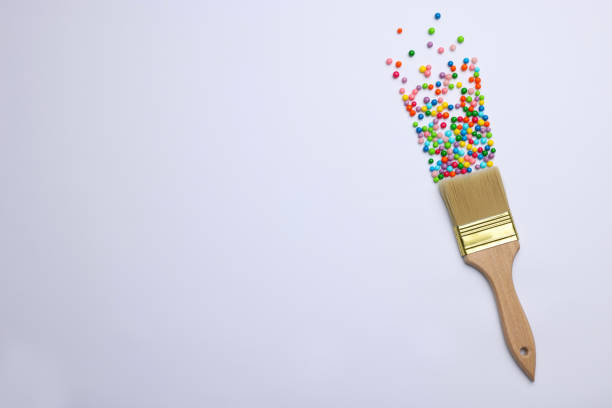 istock Brush painting with colorful sprinkles on light background, top view. Space for text. Creative concept 1454358576