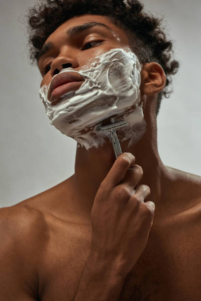 istock Partial of african american guy shaving with razor 1454358744