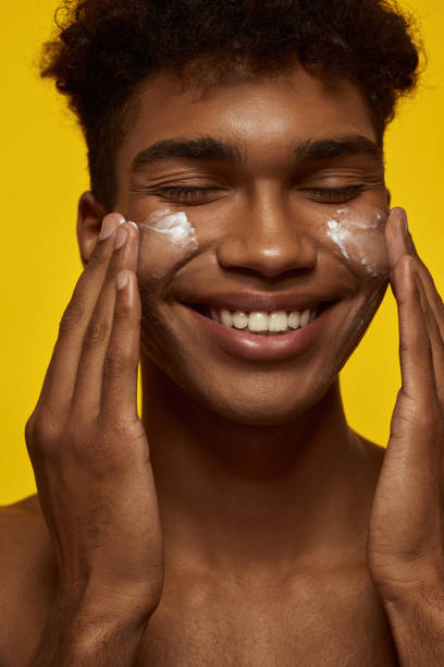 istock Cropped of smiling guy smear cream on clean face 1454359610