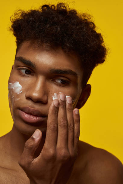 istock Cropped of serious guy smearing cream on his face 1454359655