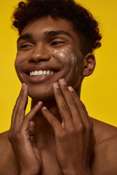 istock Partial of smiling guy smearing cream on his face 1454359690