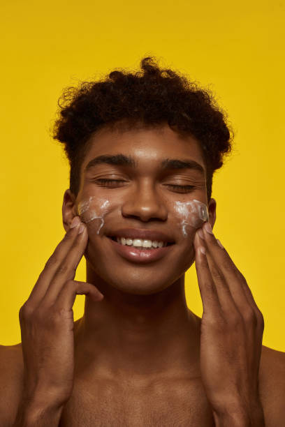 istock African american guy smearing cream on his face 1454359747