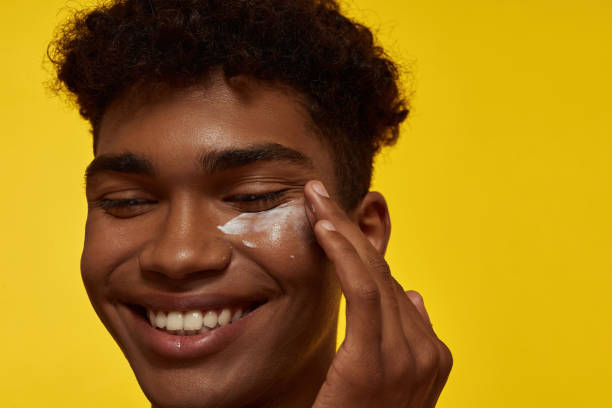 istock Guy smearing cosmetic cream on his clean face 1454360039