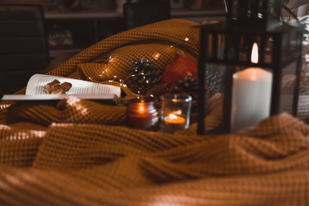 autumn photo on table with blankets, candles, pumpkin and leaves