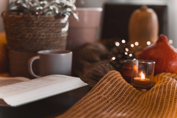 autumn photo on table with blankets, candles, pumpkin and leaves