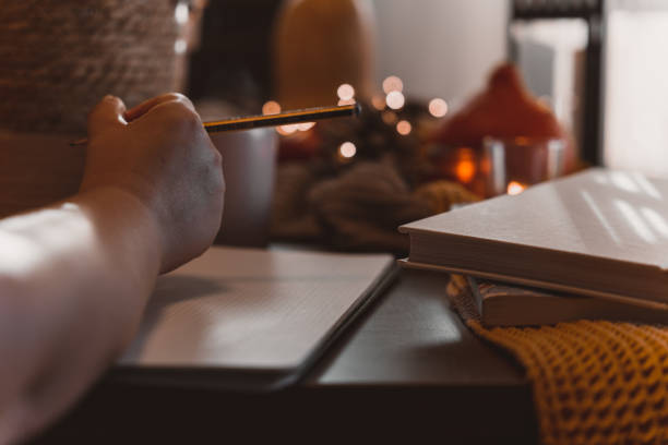 istock autumn photo on table with candles writing in a notebook 1454360980