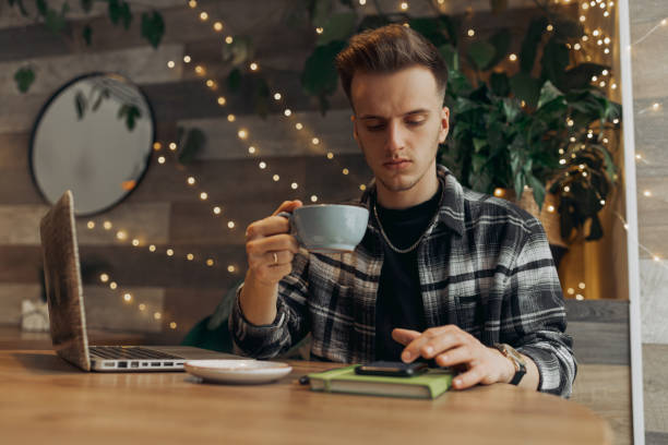 istock Digital nomad surfing internet on smartphone in coffee shop 1454363338