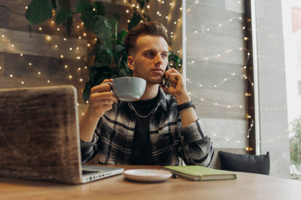 istock Freelancer making phone call during coffee break in cafe 1454363380
