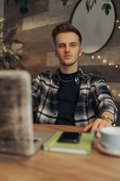 istock Cheerful young digital nomad with computer and coffee in cafe 1454363442