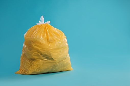 one open wrinkled yellow plastic bag isolated on white.