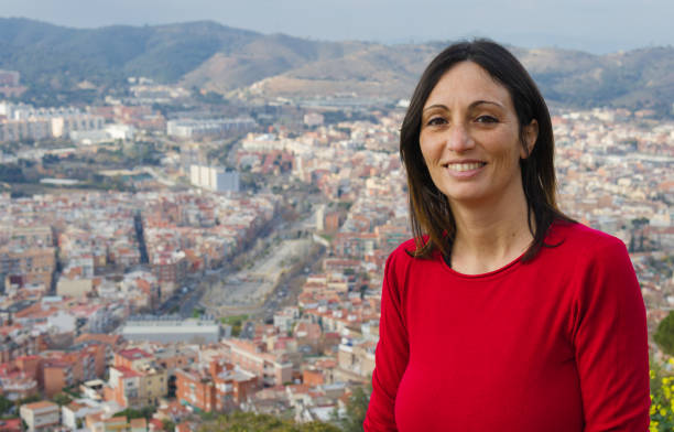 hiszpanka w średnim wieku uśmiechająca się do kamery z punktu widokowego z miastem i górą w tle - hiszpanka_& zdjęcia i obrazy z banku zdjęć