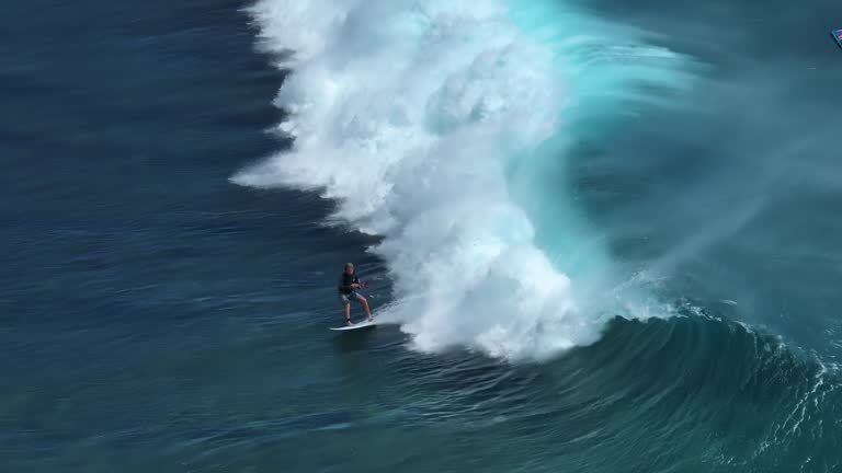 An athlete on a wave board rides the big ocean waves of a living reef in the Indian Ocean. One of the best surf spots on the planet. Sports hobby