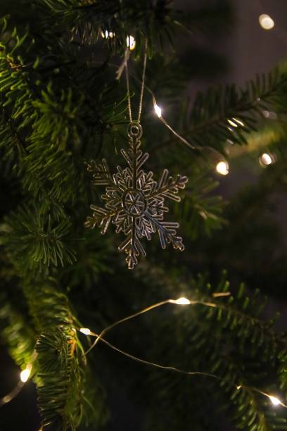 istock Vertical shot of a snowflake ornament hanging from a Christmas tree. 1454365897