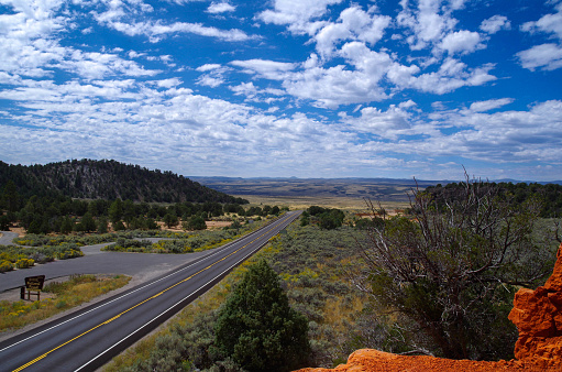 A beautiful  shot of an empty road view from Red Canyon under a blue cloudy sky