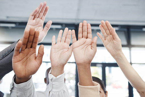 Hands, teamwork and motivation with a business man and woman group raising a hand in unity or solidarity. Meeting, goal and collaboration with a male and female employee team cheering in celebration