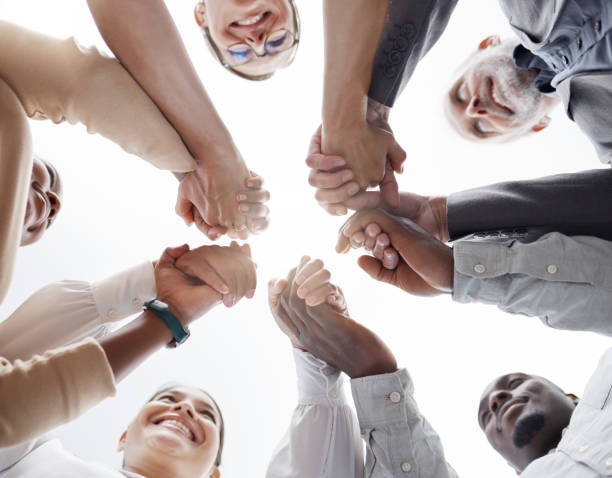 istock Hands, teamwork and motivation with a business team in a huddle or circle together from below. Collaboration, success and community with a man and woman employee group standing hand in hand in unity 1454369195