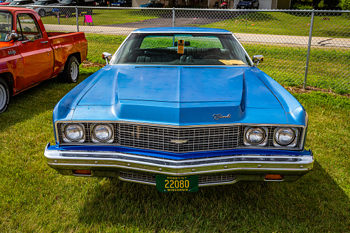 Iola, WI - July 07, 2022: High perspective front view of a 1973 Chevrolet Impala 2 Door Hardtop at a local car show.