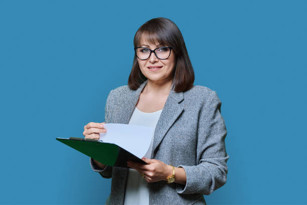 istock Business woman with clipboard on blue background 1454371455