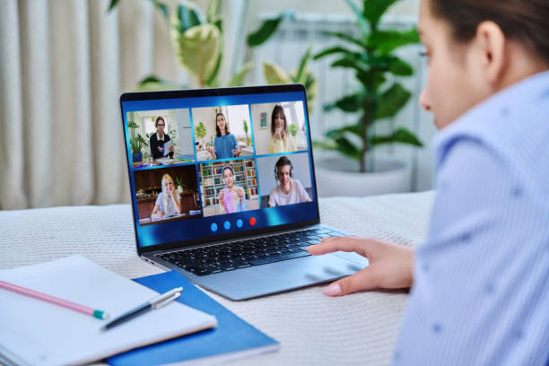 vidéoconférence, adolescente regardant l’écran d’un ordinateur portable avec un groupe d’étudiants - looking at camera smiling desk isolated photos et images de collection
