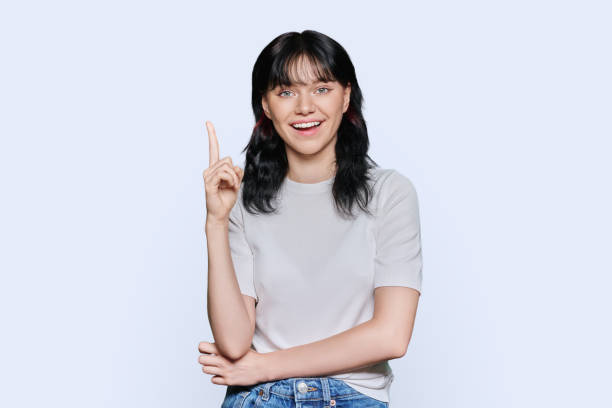 istock Happy young woman showing index finger up, over white background 1454372826