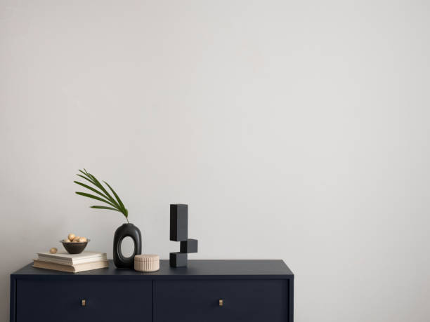 istock Minimalist composition of elegant and outstanding space with copy space, blue commode, green leaves in vase and personal accessories. Home decor. Template. 1454373072