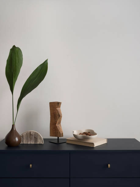 istock Minimalist composition of elegant and outstanding space with copy space, elegant blue commode, green leaves in vase, decoration and personal accessories. Home decor. Template. 1454373104
