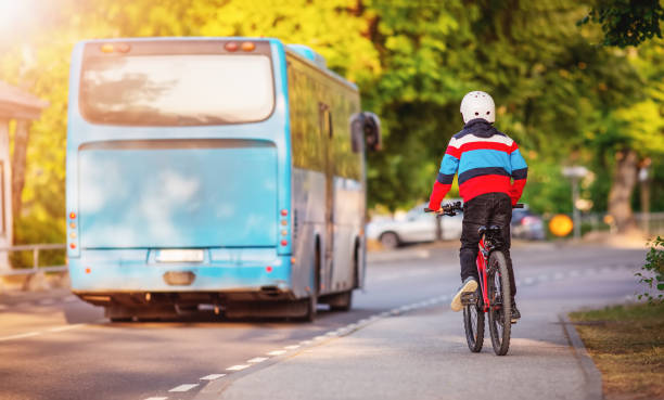 Boy on a bicycle trying to catch up with a blue bus. Boy on a bicycle trying to catch up with a blue bus. Concept of the teaching a child the rules of the road and back to school. bicycle cycling school child stock pictures, royalty-free photos & images