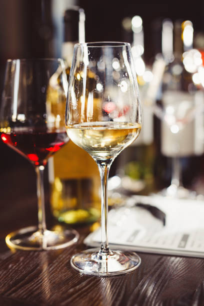 istock Glasses and bottles with tasty wines and clipboard on table 1454374789