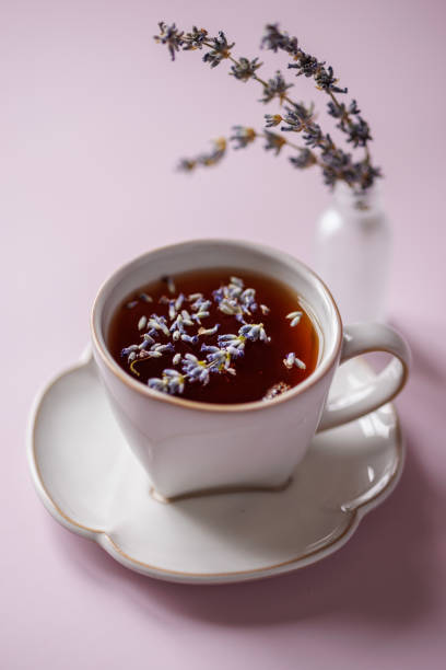 istock Black tea with lavender in a large white ceramic cup on a lilac background 1454375900