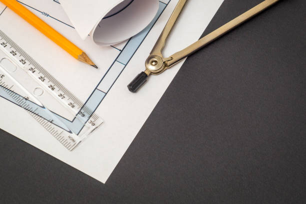 istock Rolled house diagrams and accessories for drawing lying on construction drawing on a black background 1454376289