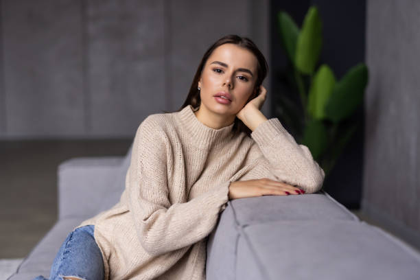 istock Happy young woman lying on couch and relaxing at home 1454376437