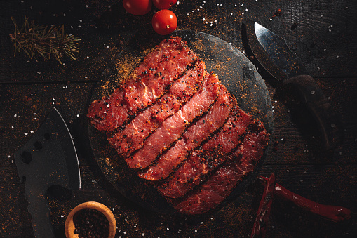 Raw beef steak fillets on dark table.
