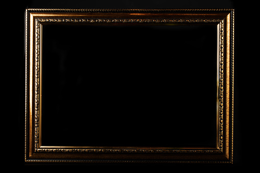 Golden classic blank frame on black background.