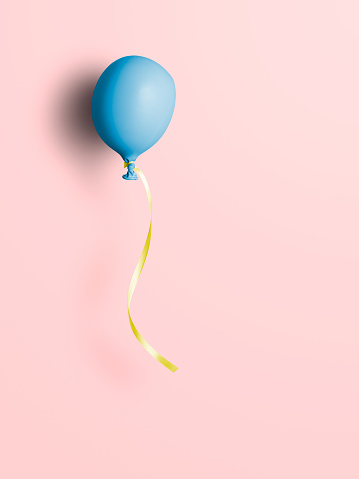 Uninflated blue balloon on pink background. This file is cleaned and retouched.