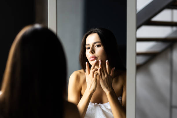 istock Young Woman looking on reflection in the mirror after shower 1454379852