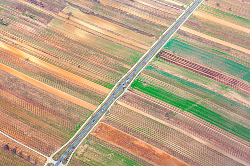Aerial view of agriculture fields and highway . Arable land view from above