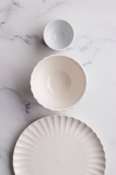 istock Empty tableware - white plate a bowl and a cup on white table as a background for a dish foodbackground 1454382678