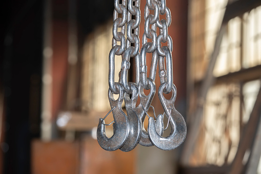 Metal chains with hooks in the workshop of a metallurgical plant.