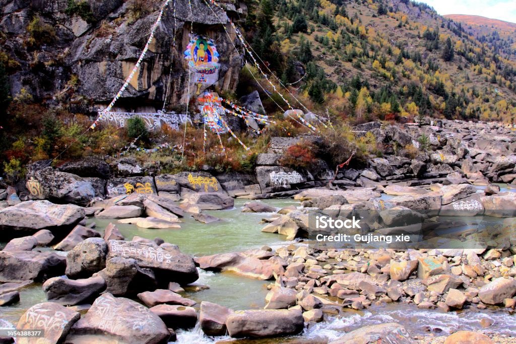 Buddha and Manidui (Marnyi Stones. stone engraved scriptures) and prayer flag on the roadside of Xinduqiao to Tagong Xinduqiao is a famous town on the 318 national Highway in western Sichuan,.The golden autumn scenery is very beautiful Autumn Stock Photo