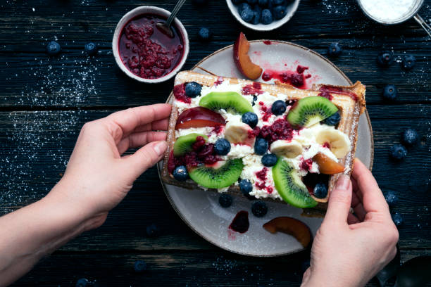 istock Belgian waffles with fruits in hands 1454390474