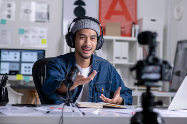 Young Asian male graphic designer recording video content for online lesson.