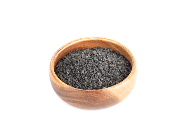 istock Wooden bowl with black salt isolated on white background. 1454392272
