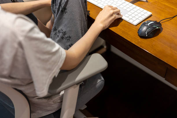 Woman is using a computer with a bad posture Woman is using a computer with a bad posture legs crossed at knee stock pictures, royalty-free photos & images