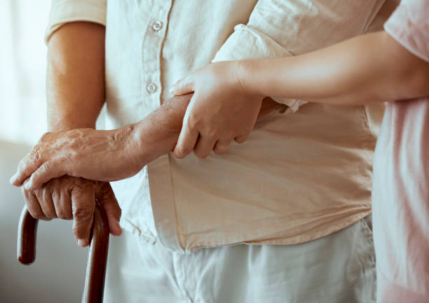 istock Support, disability and caregiver with senior patient helping him walk in retirement hands zoom and walking stick. Physical therapy, nurse medical professional help elderly or old man in nursing home 1454394000
