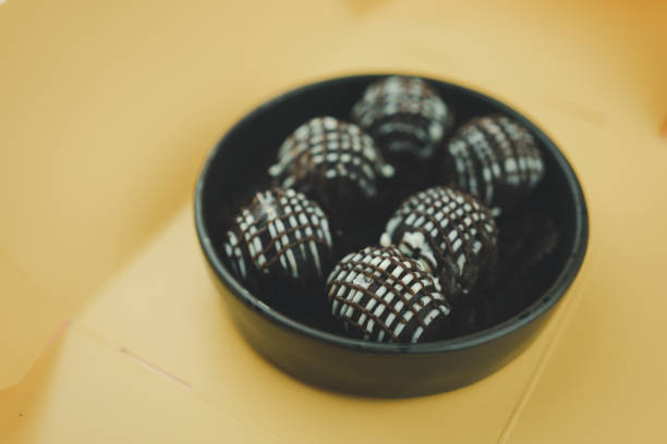 Delicious chocolate corn balls topped with sauce chocolate and sauce vanilla opened from a yellow box