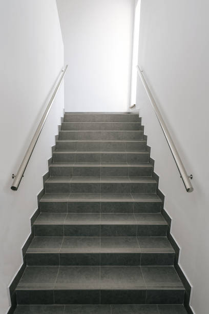 istock Ladder in office building. Steps covered with gray ceramic tiles (porcelain stoneware). 1454395178