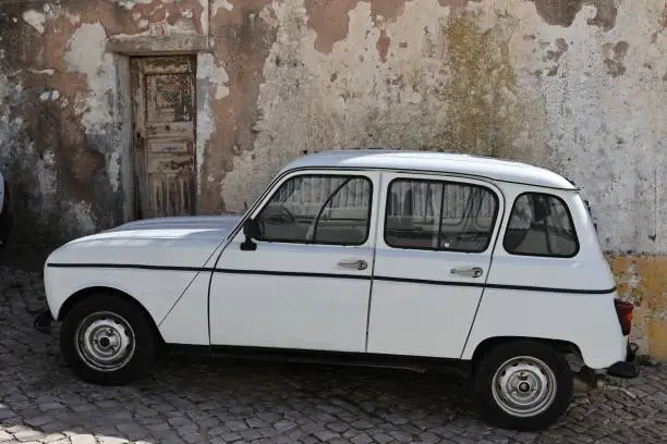 Photo of Vintage old white Renault 4L on the side of a road